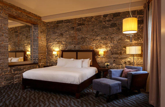 Chambre grand lit avec mur de pierre