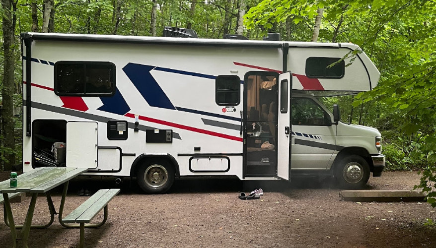 En RV, on s’installe une seule fois : les valises, chaussures et affaires de toute la famille restent à leur place pendant que la maison, elle, change de décor. RV au Canada avec coffre de rangement ouvert