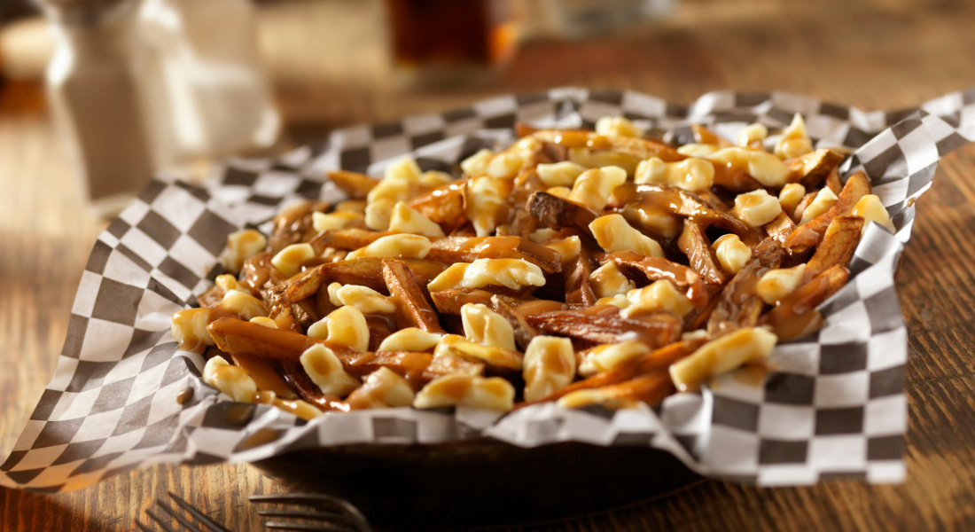 Poutine québécoise servie avec des frites, du fromage en grains et une sauce brune chaude