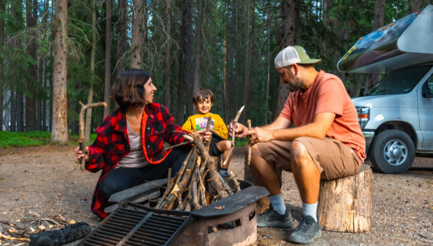 La vie en camping se passe beaucoup dehors : on installe son campement, on croise ses voisins et la conversation vient naturellement. Un petit coup de main ou une question pratique suffit souvent pour faire connaissance. Famille installant son campement en RV au Canada