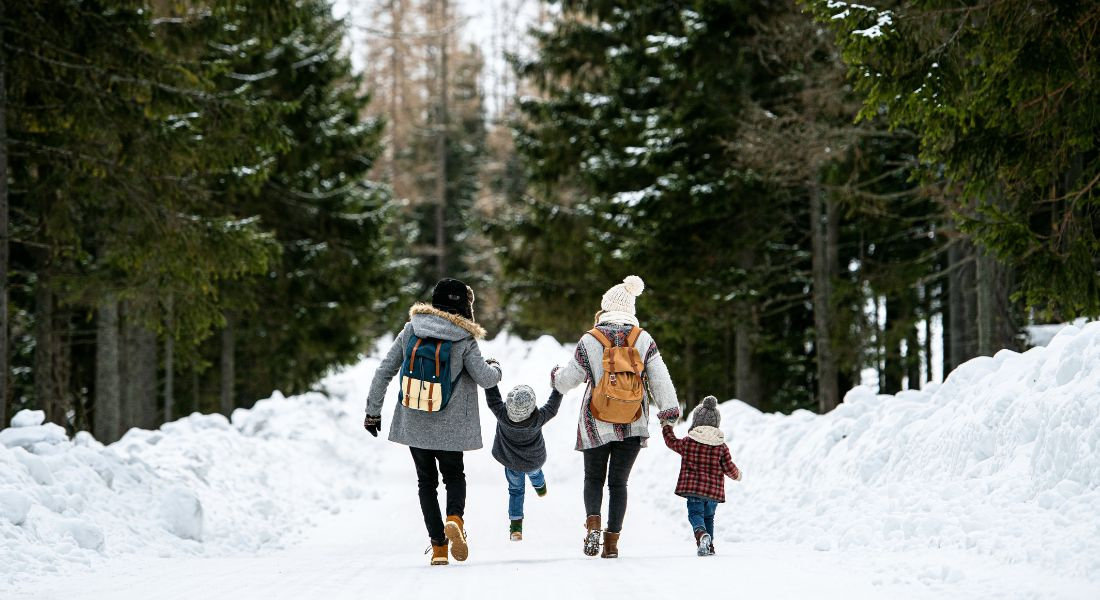 Balade famille neige Parc de la Jacques-Cartier Famille avec 2 enfants se promenant dans la forêt enneigée