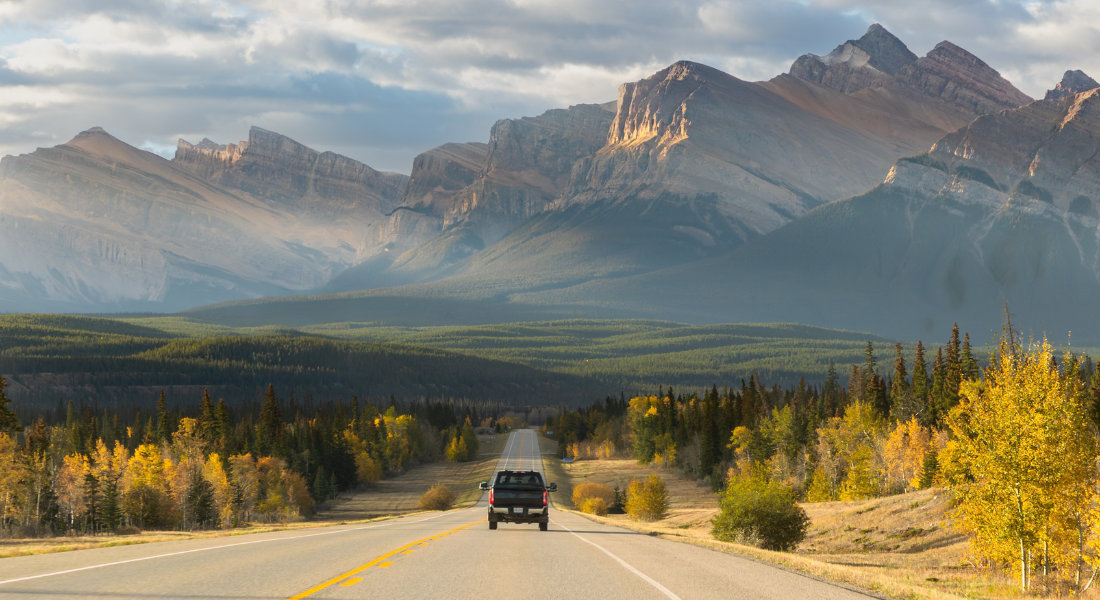 Choosing the right travel agency for Canada Car on a road in the middle of the Canadian Rockies