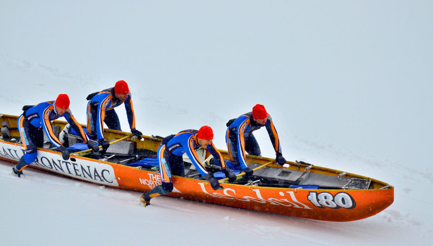 Ice canoeing Four men on each side of a canoe sliding on ice