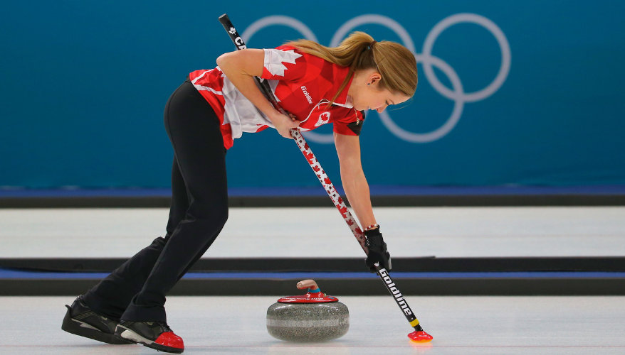 Curling A woman sweeping the ice to help a curling stone slide as far as possible