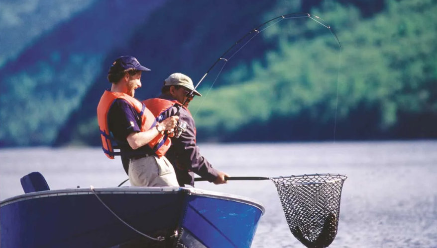 Fishing at an outfitter Two fishermen in a boat trout fishing on a lake in Quebec.