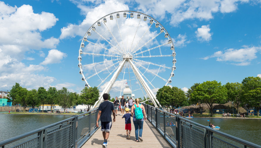 Grande roue de montréal A family walking towards the Grande Roue de Montréal in the Old Port on a summer day.