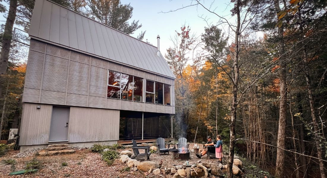 Cabin in the woods in Quebec and family around a fire