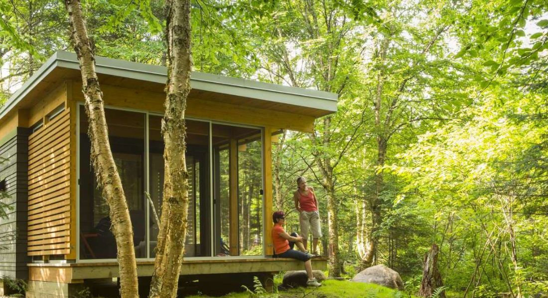 Chalet du parc de la Jacques-Cartier au Québec Deux personnes admirant le paysage depuis leur chalet dans la forêt