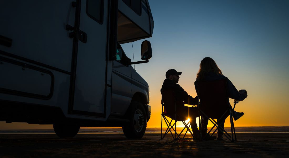 Compare the inclusions carefully Traveler in front of their RV at sunset
