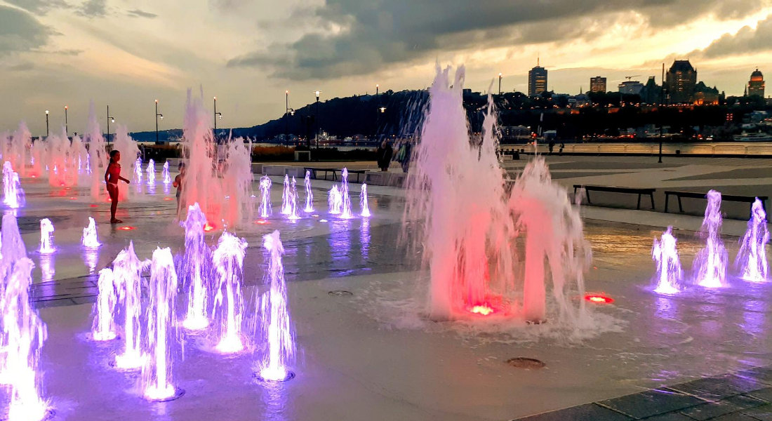 Fontaine illuminé du Quai Paquet au coucher du soleil avec le château Frontenac en arrière plan