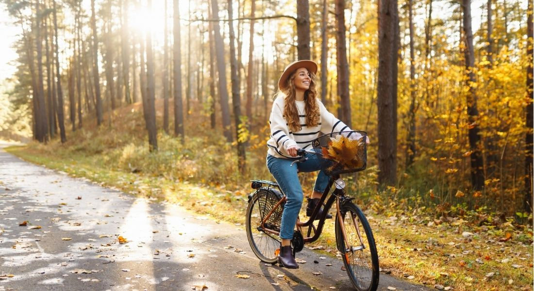Faire du vélo en automne au Québec Jeune femme sur un vélo dans la forêt