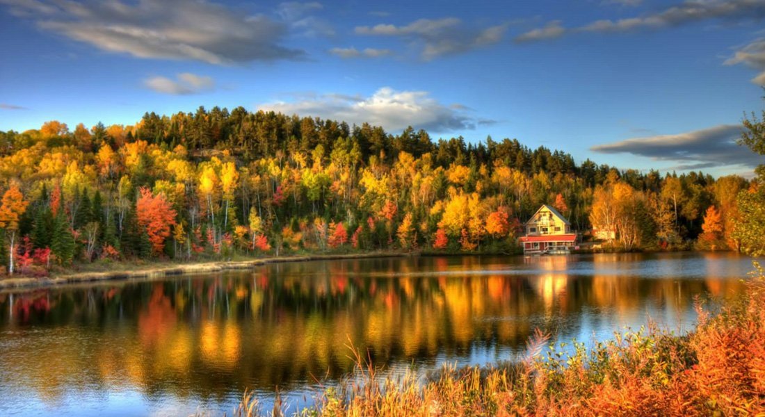 Chalet au bord d'un lac durant l'automne 