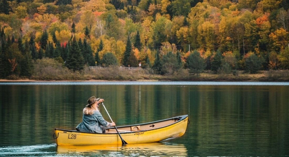 jeune femme dans un canot en automne