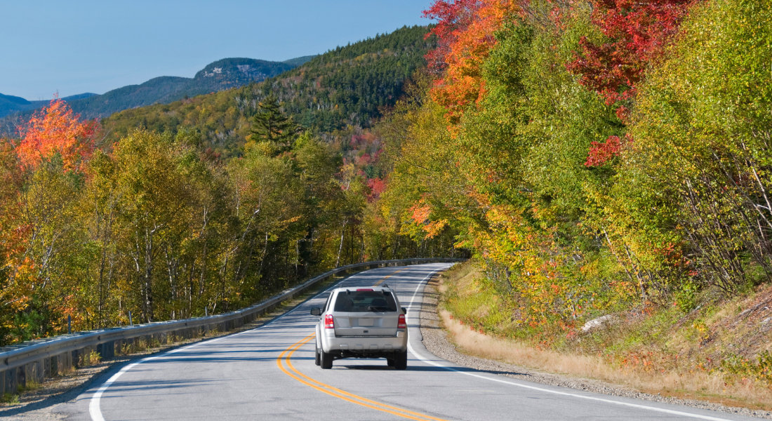 Book the right car hire deal at the right time in Canada Car driving along a colourful autumn road in Canada
