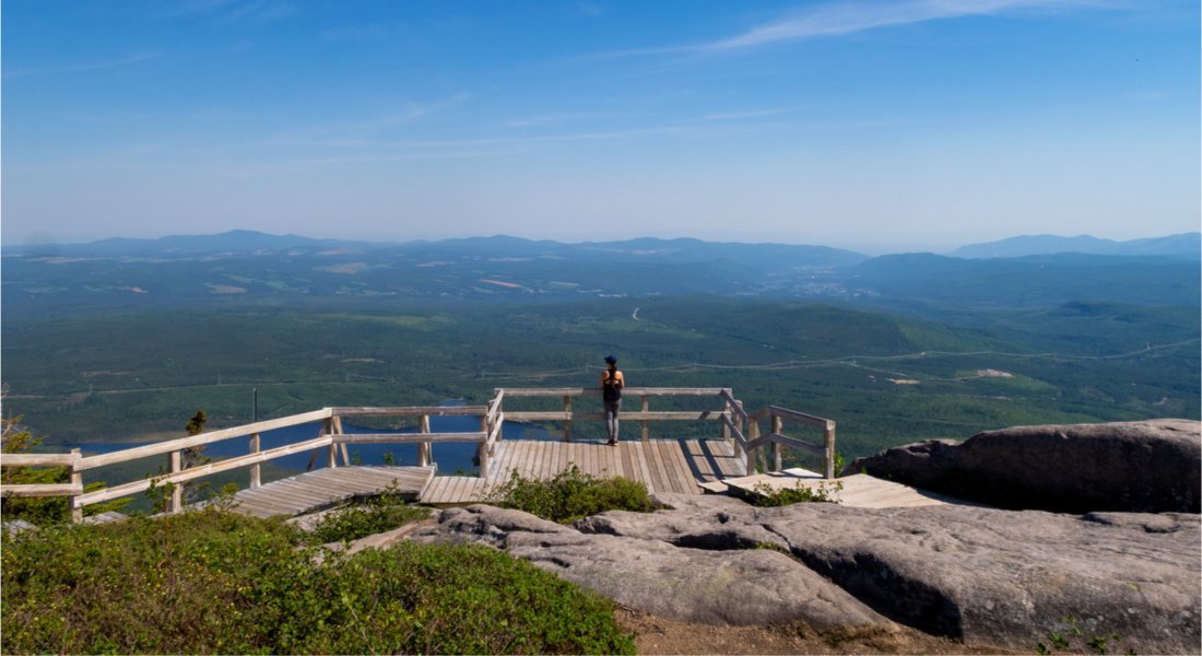 Randonneuse sur le belvédère de bois au sommet de la randonnée du Mont du  Lac des Cygnes dans Charlevoix