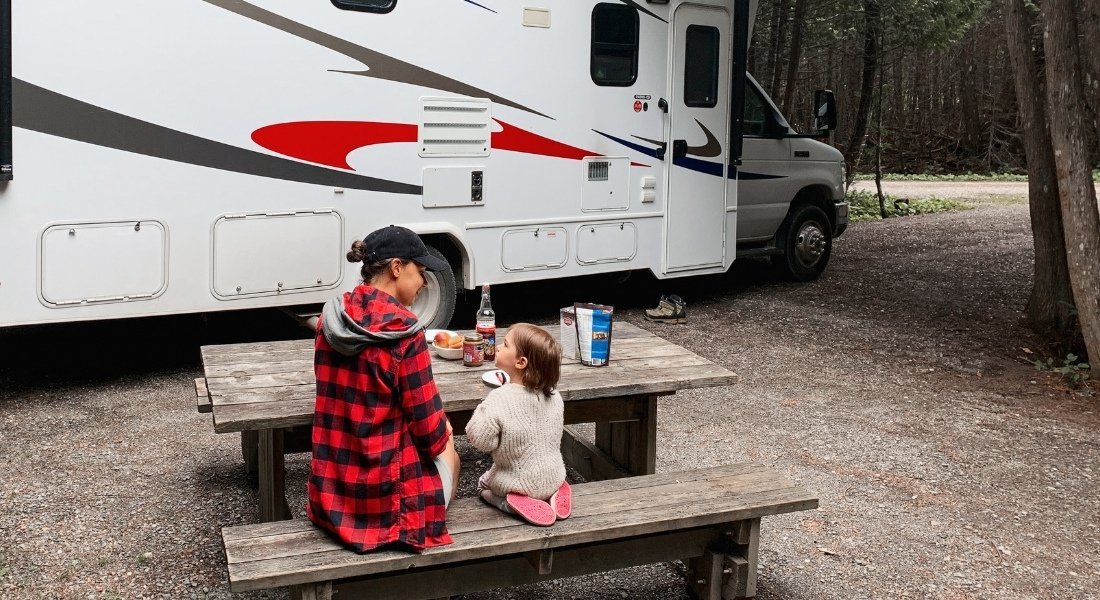 null Une maman et sa petite fille à une table de pique nique sur un emplacement de camping