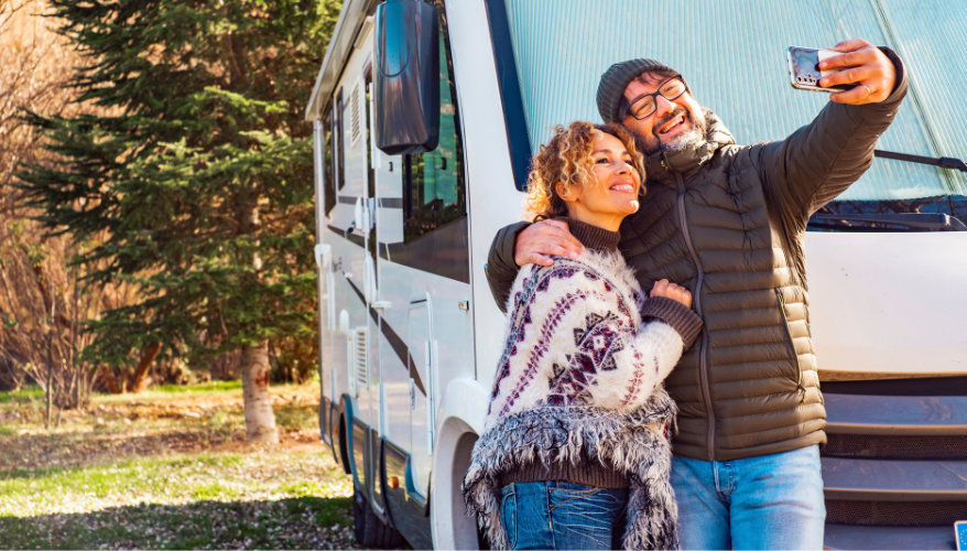 So, what should you choose? Happy couple taking a selfie in front of their motorhome