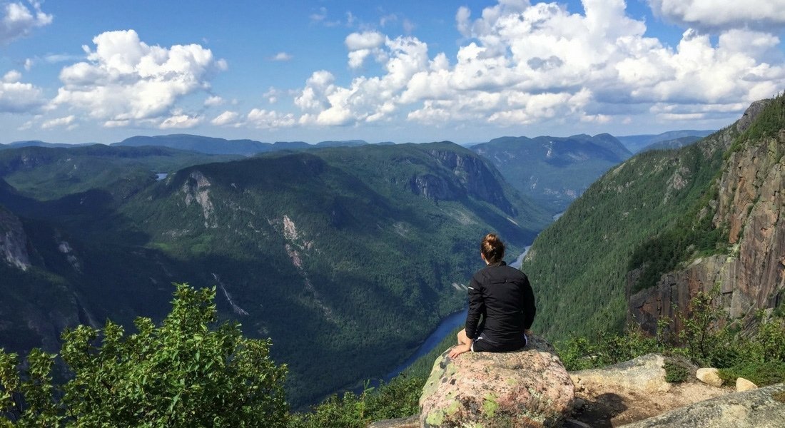 Hiker at the summit of the Acropole des Draveurs during a Quebec road trip