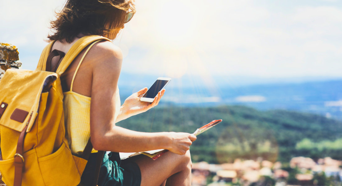 femme regardant son telephone en haut d'un point de vue