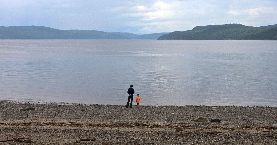 deux personnes qui admirent le paysage depuis la plage