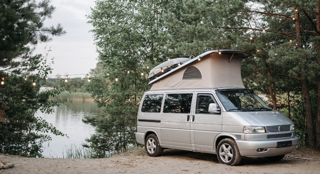 Van with pop-up roof in front of a river in Canada