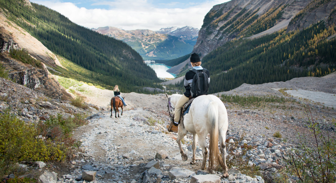 2 personnes en balade à cheval dans le parc national de Banff