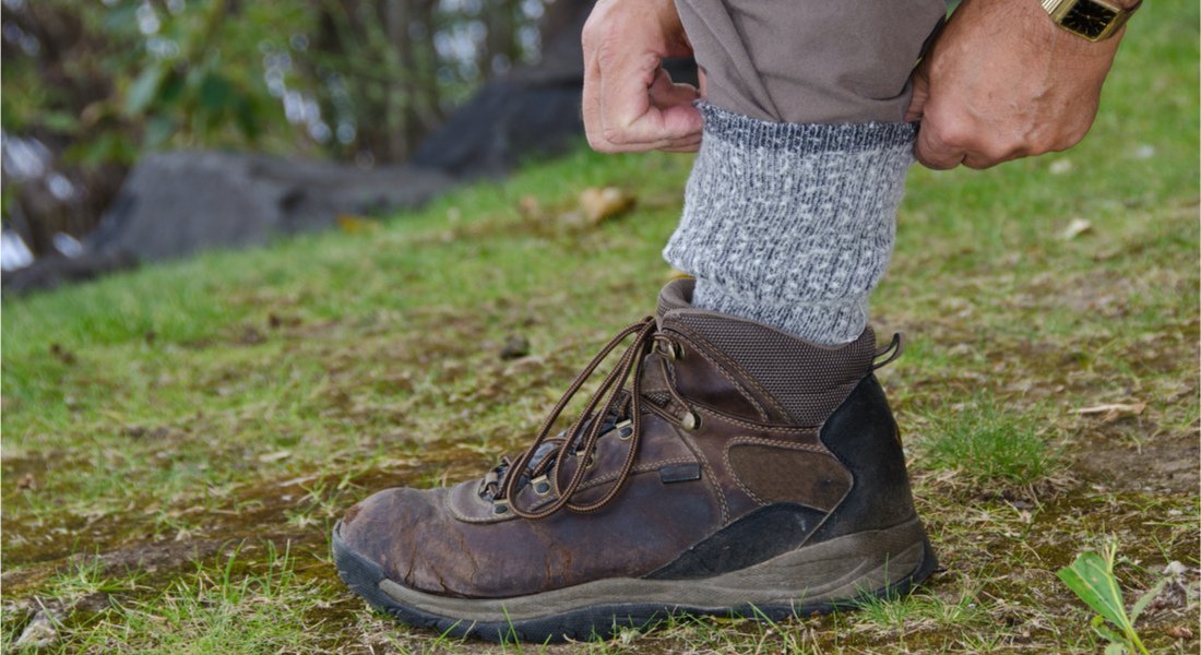 Randonneur recouvrant sont bas de pantalon avec sa chaussette pour éviter les tiques