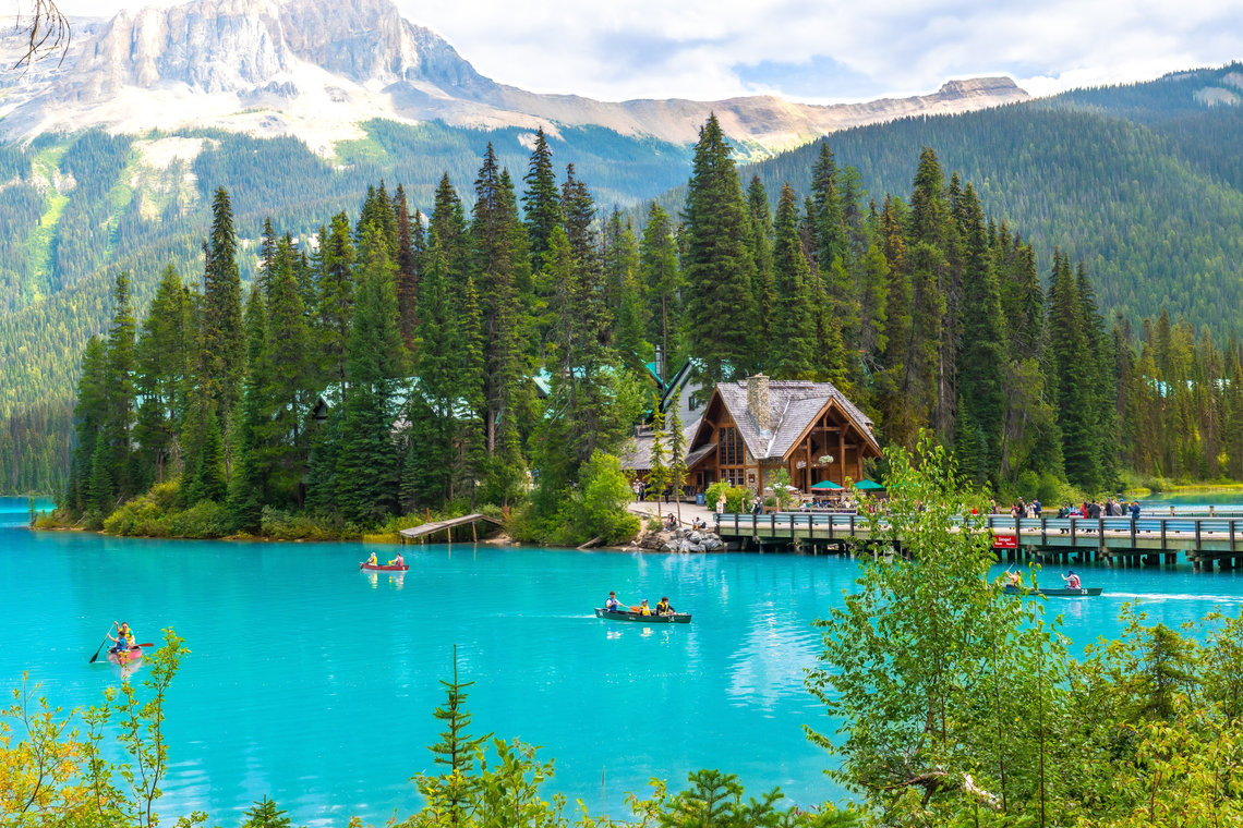Canoes on the turquoise waters of Emerald Lake, surrounded by forests and mountains.