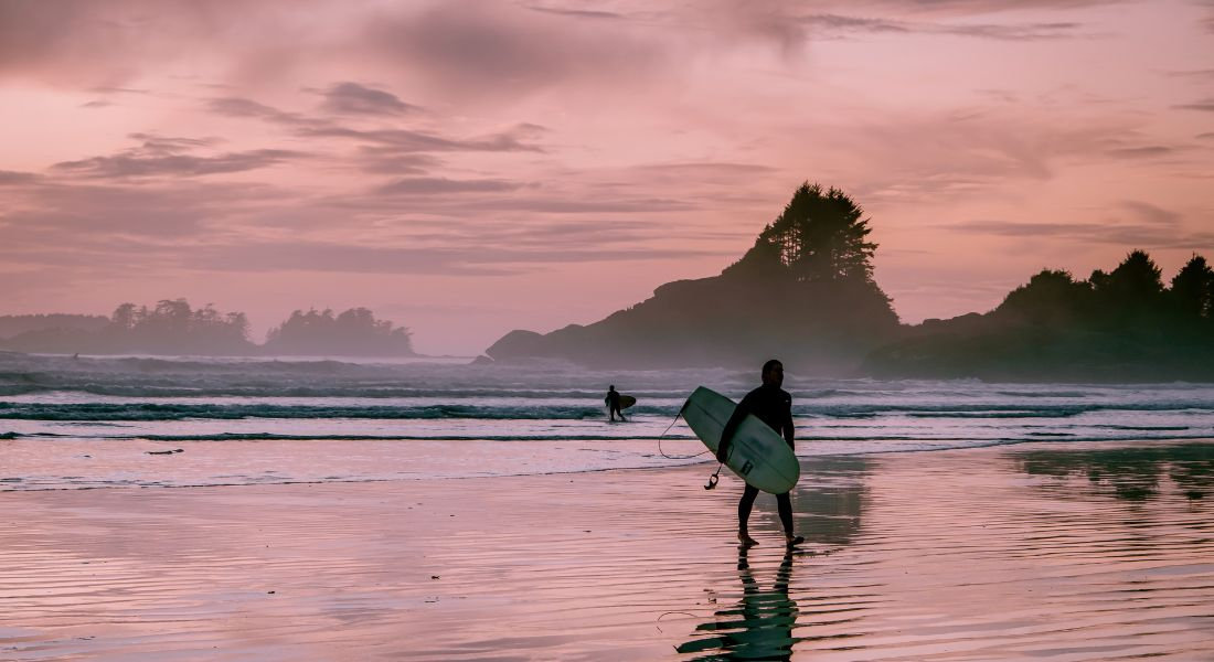 Surfeur sur la plage au coucher du soleil