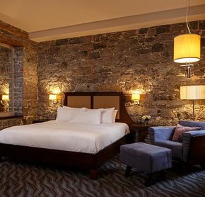 Chambre grand lit avec mur de pierre