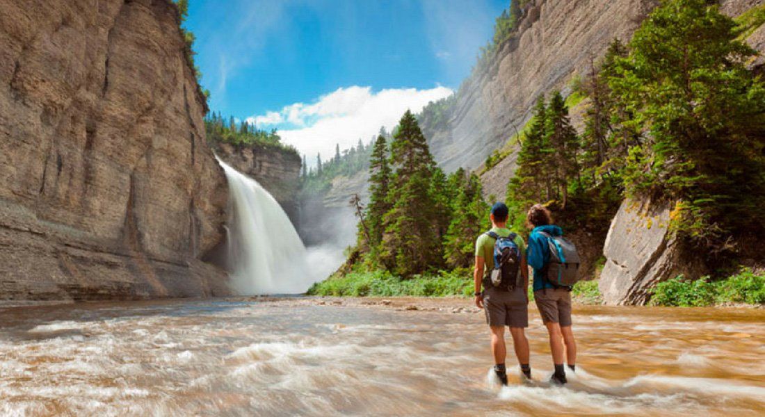 Deux randonneurs devant la chute Vauréal sur Ile d'Anticosti