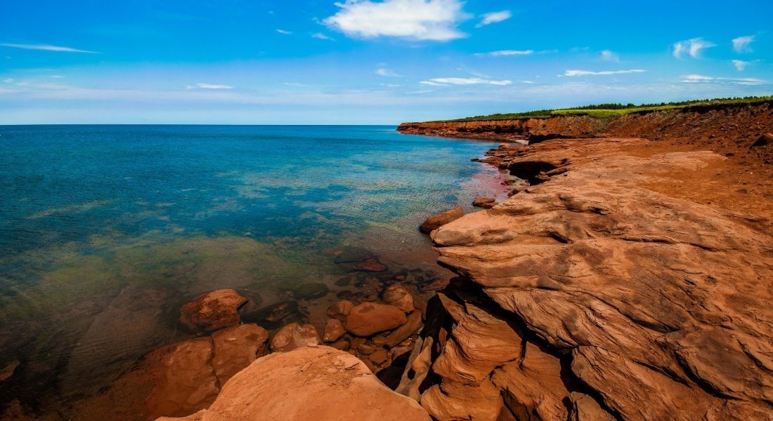 La côte du parc national de l'Île-du-Prince-Édouard Eau turquoise et roches oranges de la côte du parc national de l'Île-du-Prince-Édouard