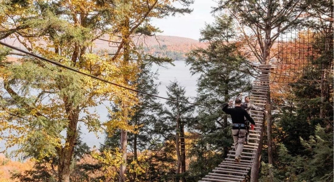 Accrobranche au Québec Passerelle en bois entre deux arbres avec vue sur la rivière en contre-bas