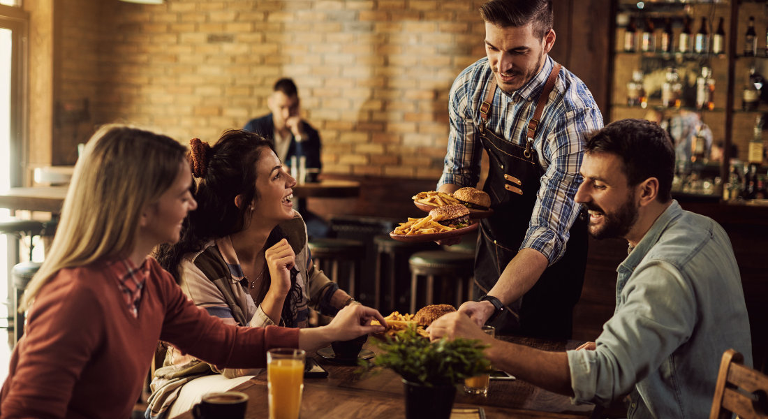 Parler anglais au quotidien pendant son voyage Un groupe d'ami dans un restaurant, le serveur leur apporte des burgers