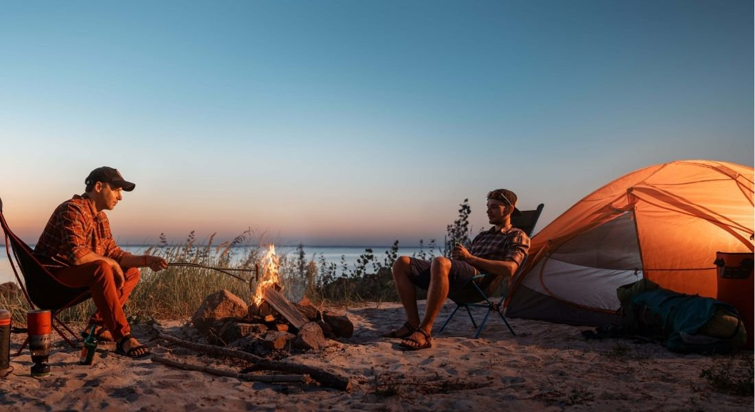 Camper à Big Sur en Californie Deux personnes devant leur tente au bord de l'océan