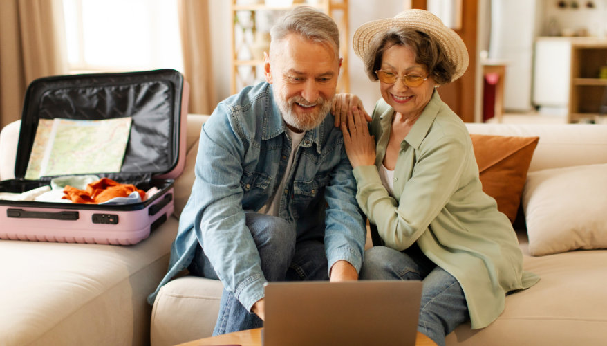 Couple qui réserve leur voyage en ligne sur leur laptop