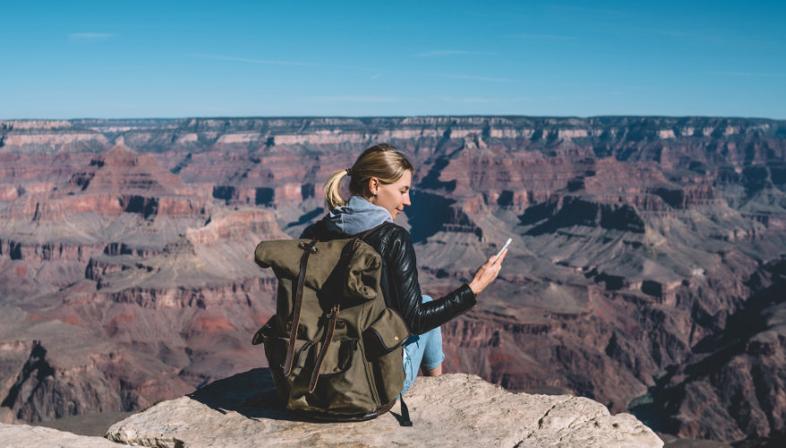 Femme au Grand Canyon qui est sur son téléphone