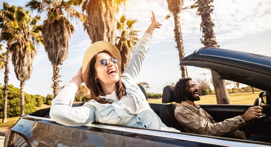 @Xavier Lorenzo - shutterstock_2143697769 Couple en voiture avec vue sur des palmiers en Floride