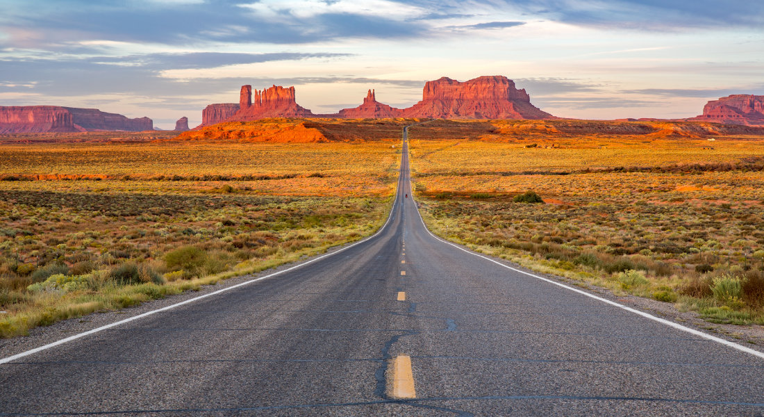 An unchanged experience Road running through Monument Valley at sunset