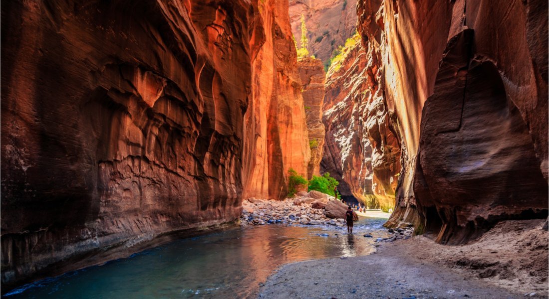 @Stephen Moehle - shutterstock_1714173328 Hikers walking through water on the Zion Narrows hike