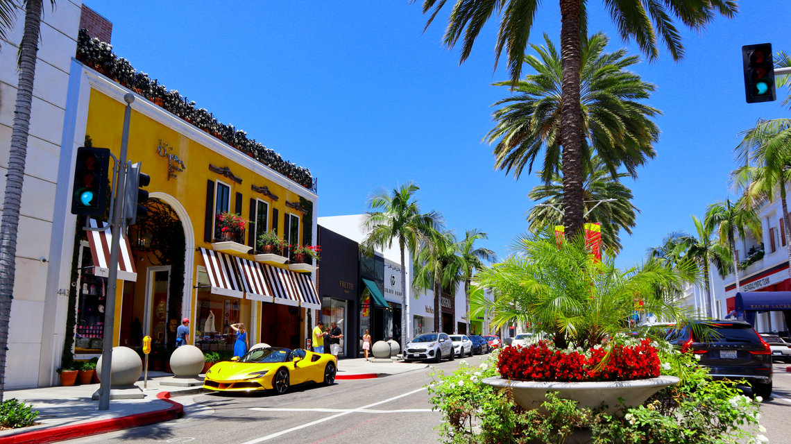 Beverly Hills Street lined with palm trees and luxury shops on Rodeo Drive in Beverly Hills