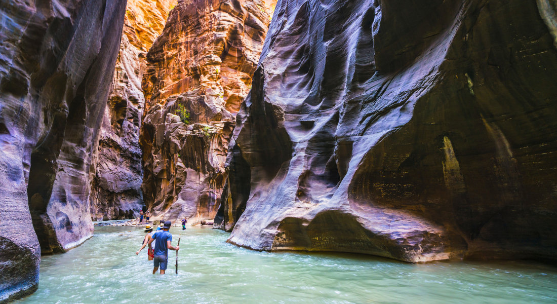 Hiking with your feet in the water Hikers wading in the water along the Virgin River in Zion