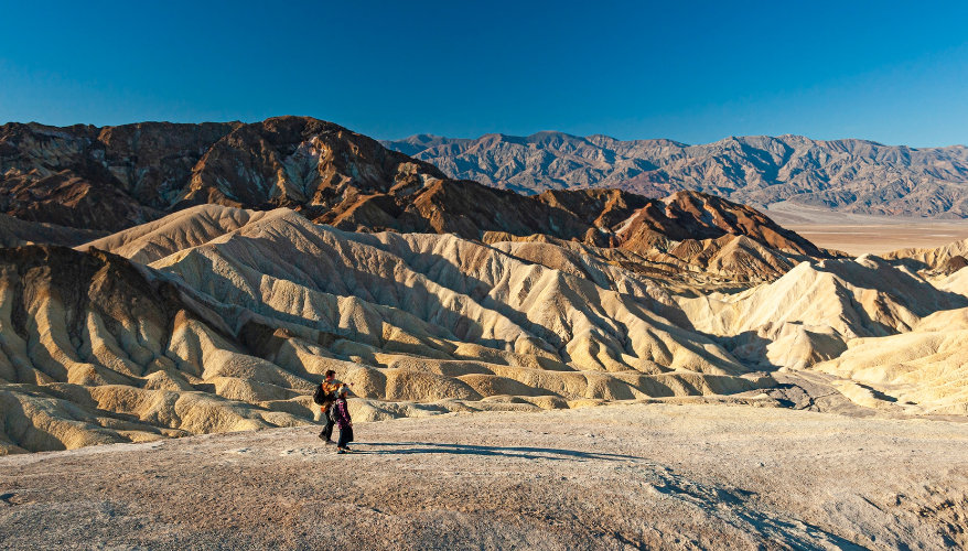 Zabriskie Point in Death Valley Two hikers admiring the rock formations at Zabriskie Point in Death Valley, California