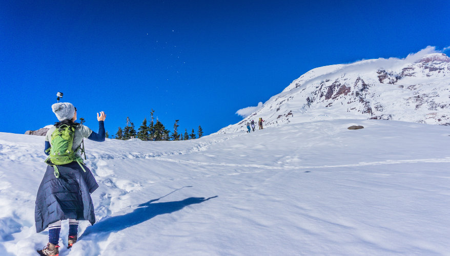 Winter hiking in the USA Hiker in winter gear on a snow-covered trail with a mountain in the background