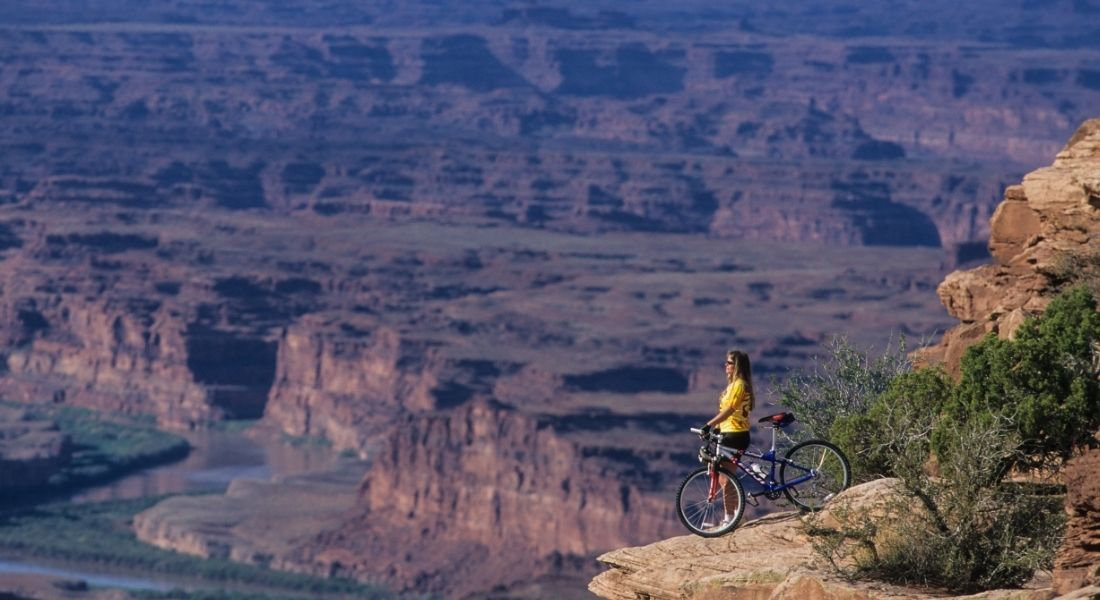 VTT Dead Horse Point State Park Femme à côté de son vélo observant le paysage de Dead Horse Point State Park