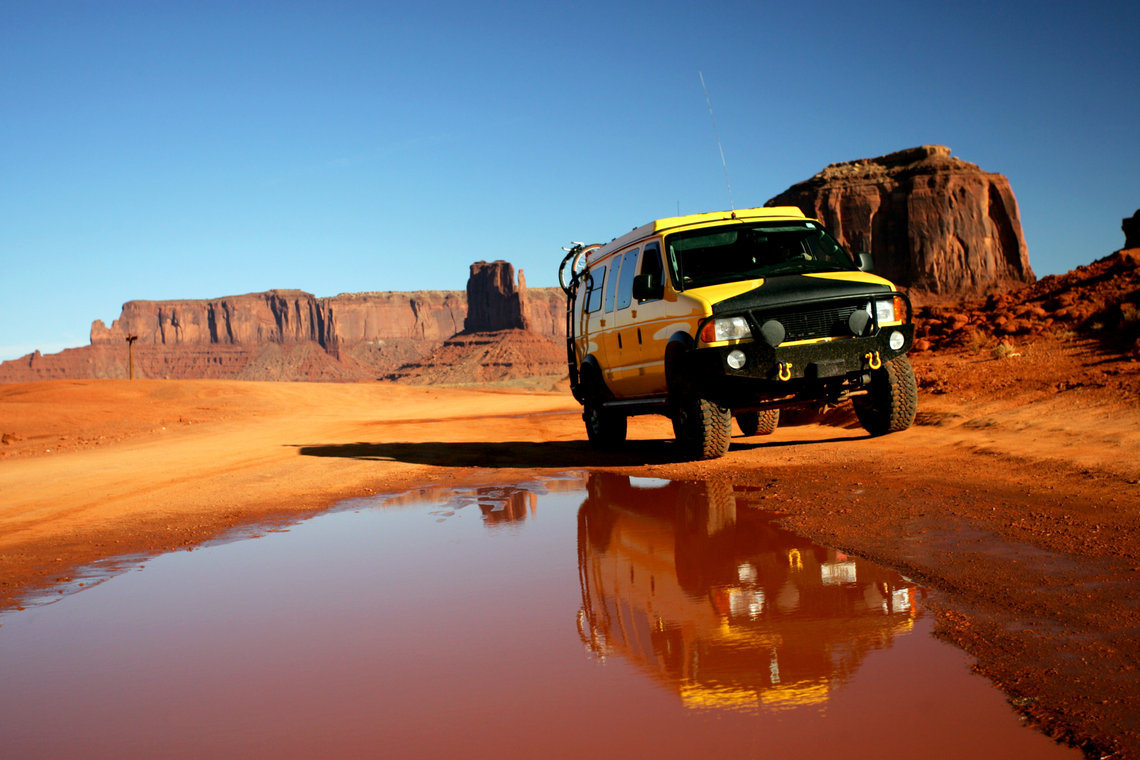 Un 4x4 au coeur de Mobument Valley sous le soleil