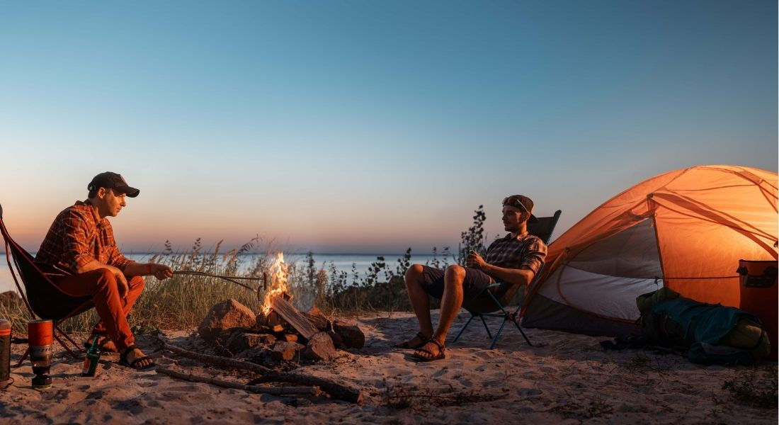 Camper à Big Sur en Californie Deux personnes devant leur tente au bord de l'océan