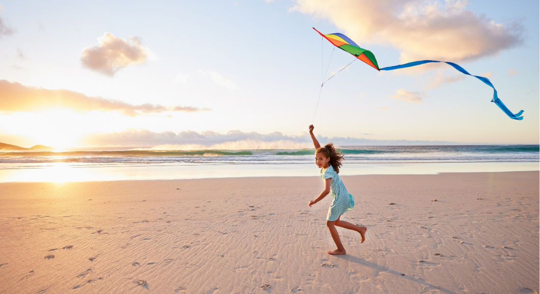 Coopers Beach sur la côte atlantique américaine Petite fille jouant au cerf-volant sur la plage au coucher du soleil