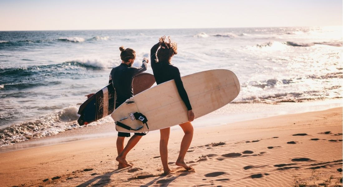 Surfer à Big Sur en Californie Deux surfeurs marchant au bord de l'eau avec leurs planches sous le bras
