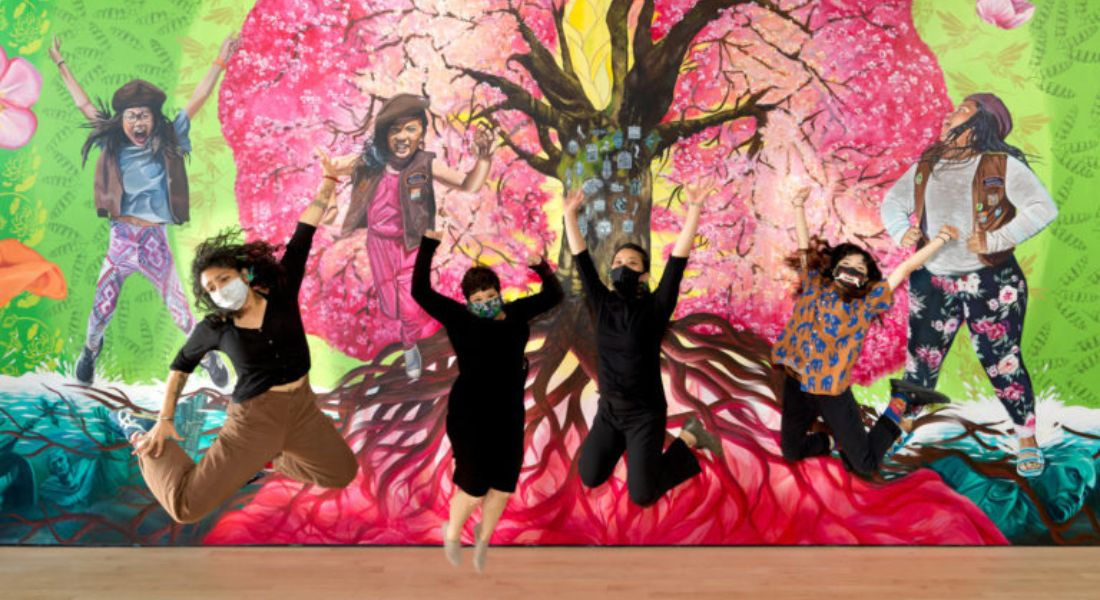 Quatre personnes sautant de joie devant une oeuvre d'art